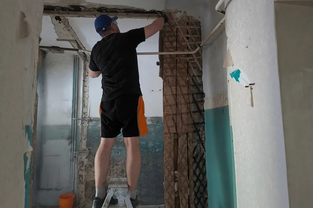 Facharbeiter entfernt professionell Innenwand einer Wohnung