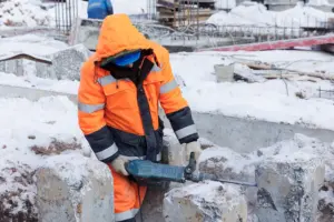 Facharbeiter der im Winter Abbrucharbeiten durchführt
