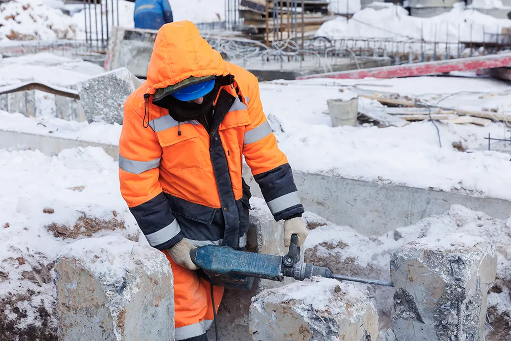 Facharbeiter der im Winter Abbrucharbeiten durchführt Facharbeiter der im Winter Abbrucharbeiten durchführt