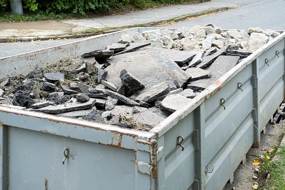 Grosser überfüllter Müllcontainer mit Bauabfall