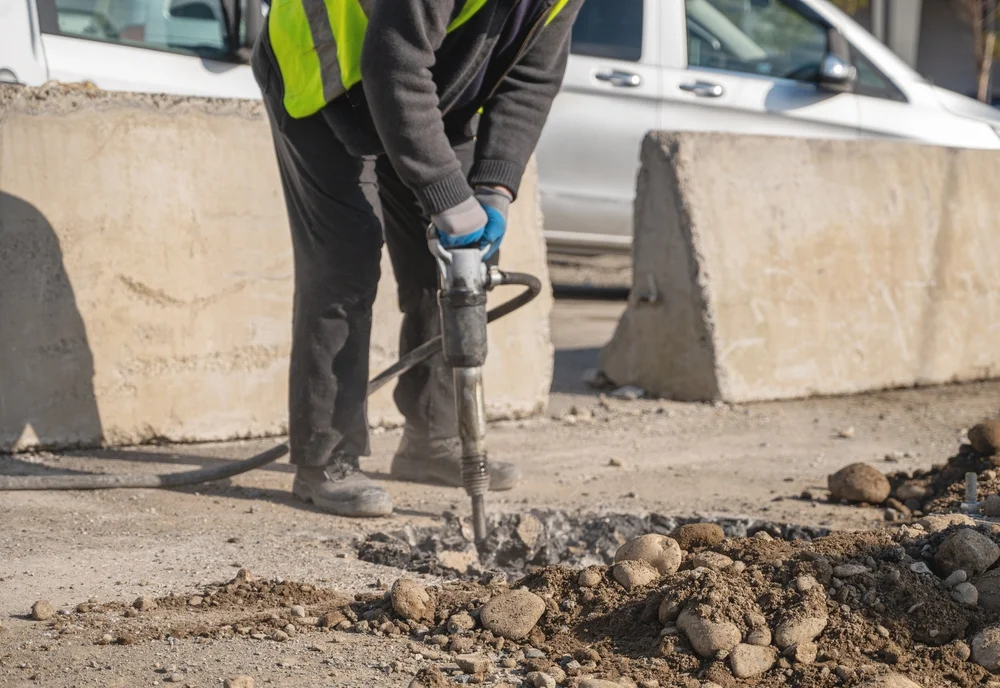 Bauarbeiter mit Presslufthammer – Betonabbruch und Vibrationswirkung